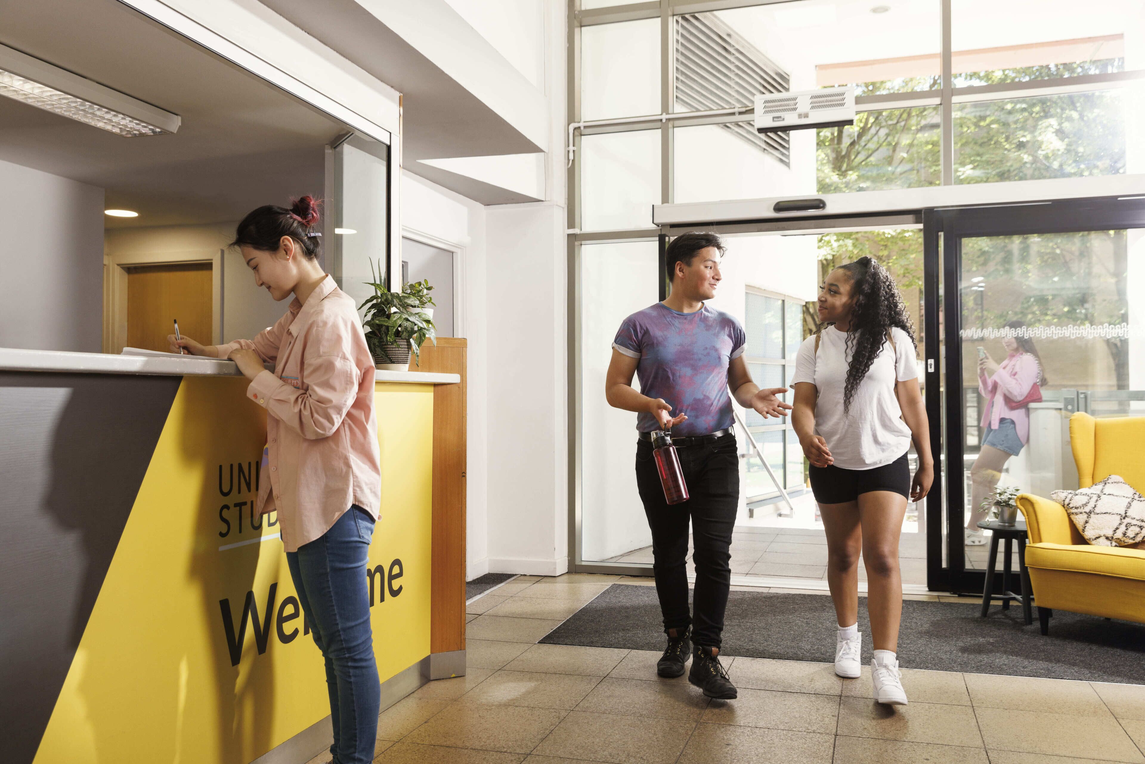 A reception area with a 'Welcome' sign, a reception desk, and a yellow couch.