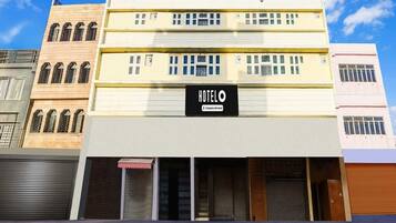 A hotel with a sign reading 'HOTEL' and a company-serviced logo.