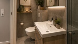 Een moderne badkamer met een grote spiegel, een wastafel en een toilet.