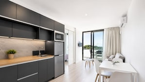 A modern kitchen with dark cabinetry, a wooden countertop, and a built-in oven. - Romantic Coastal Apartment Hideaway (Castell-Platja d'Aro)