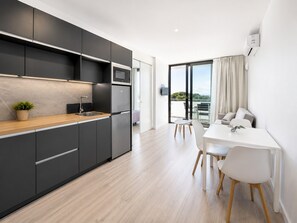 A modern kitchen with dark cabinetry, a wooden countertop, and a built-in oven. - Romantic Coastal Apartment Hideaway (Castell-Platja d'Aro)