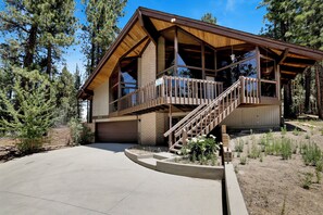 A two-story log cabin with a balcony, a garage, and a driveway. - 4BR/3BA Big Bear Lake Retreat w/ Forest View (Big Bear Lake)