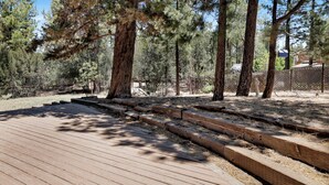 Eine Holzterrasse mit Stufen, die in einen Wald führen.