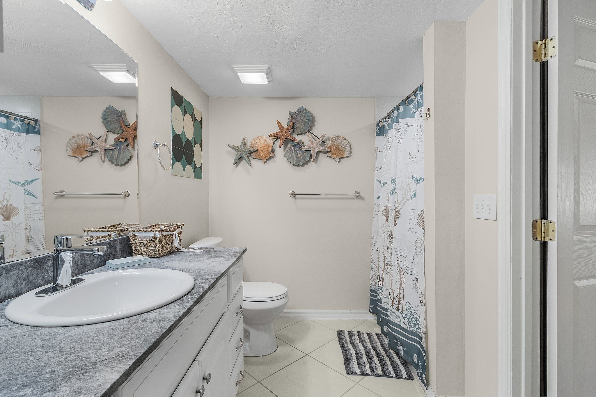 Een badkamer met een wit wastafelmeubel, toilet en douche.