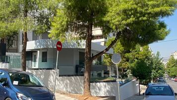 A street with parked cars, a no entry sign, and a tree.