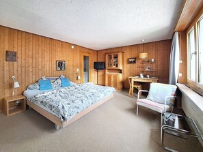 A room with a bed, a desk, a chair, and a television. - Chalet Willi-Parterre Appartement/Fewo, Dusche, WC, 2-Bettwohnung by Interhome (Arosa)