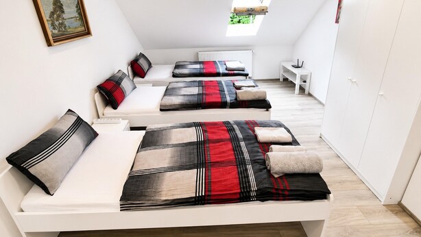 A room with three beds, a radiator, a window, and a wardrobe. - Apartment in Barmen (Wuppertal)