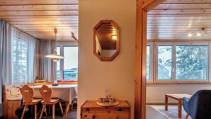 Et træinteriør med spiseplads, et skuffedarium og en stol.