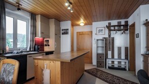 Una cocina con armarios de madera, una isla central, un fregadero y un ventanal.