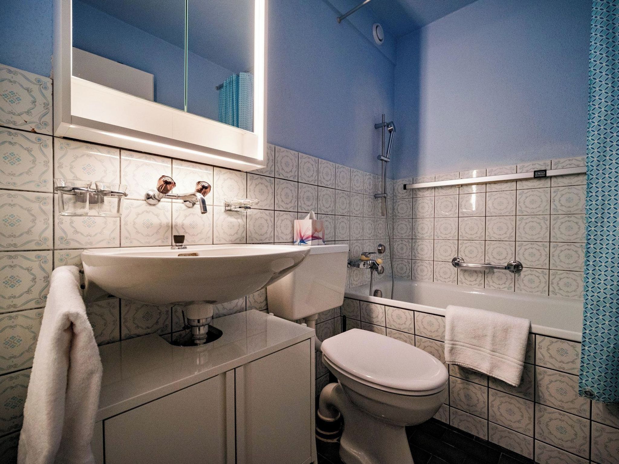 Un baño con lavamanos, inodoro y ducha.