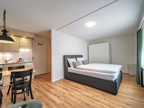 A compact bedroom with a bed, a desk, and a kitchenette. - Paradies 212 Appartement/Fewo,  , 2-Bettwohnung 2-Bettwohnung by Interhome (Arosa)