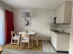 Eine kompakte Küche mit Essbereich, einer gemusterten Lampe und einer Kücheninsel.