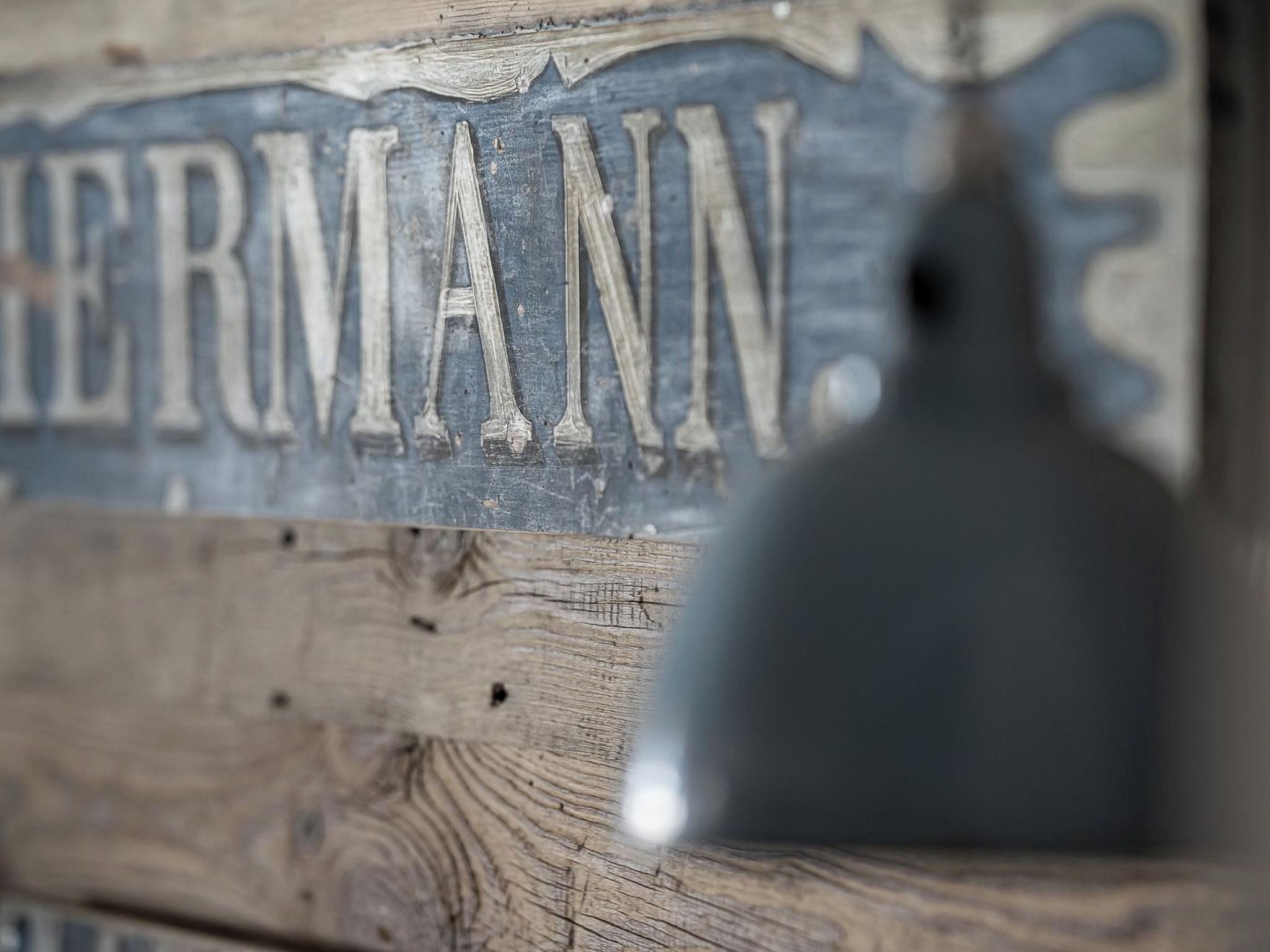 Primer plano de un letrero de madera con el nombre 'HERMANN' grabado.
