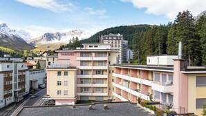 Ett hotell med flera våningar, balkonger och utsikt över bergen.