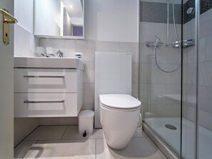 A modern bathroom with a toilet, sink, and shower. - Paradies 206 Appartement/Fewo, Dusche, WC, 2-Bettwohnung 2-Bettwohnung by Interhome (Arosa)