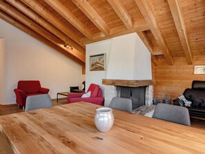 Ein Holzinterieur mit hohen Decken, einem Kamin und Sitzgelegenheiten.