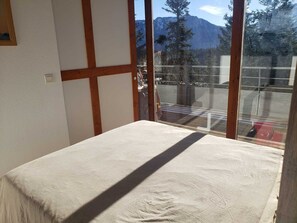 A room with a large window, wooden beams, and a view of mountains. - Apartment in Chamrousse - 4 guests (Chamrousse)