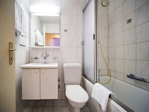 Une salle de bain comprenant des toilettes, un lavabo et un espace douche.