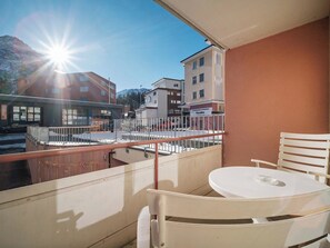 A balcony with a table and chairs, overlooking a parking area and buildings. - Paradies 002 Appartement/Fewo,  , 3-Bettwohnung 3-Bettwohnung by Interhome (Arosa)