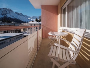 A balcony with a table and two chairs, overlooking a snowy mountain range. - Paradies 606 Appartement/Fewo, Bad, WC, 2-Bettwohnung by Interhome (Arosa)