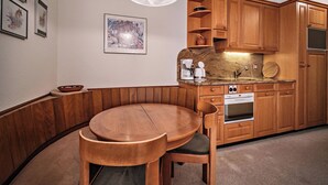 Una cocina con armarios de madera, una mesa de comedor redonda y una cafetera.