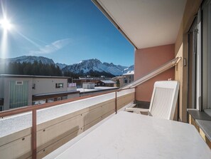 A balcony with a view of snow-capped mountains, a wooden railing, and a table. - Paradies 506 Appartement/Fewo,  , 2-Bettwohnung 2-Bettwohnung by Interhome (Arosa)