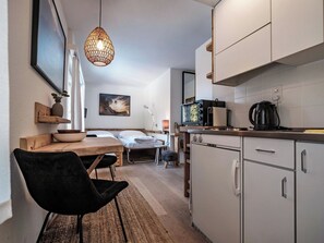 A compact living space with a kitchenette, a dining area, and a bed. - Paradies 603 Appartement/Fewo,  , 1-Bettwohnung 1-Bettwohnung by Interhome (Arosa)