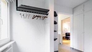 Un pasillo con un perchero, un radiador y una puerta que da a otra habitación.