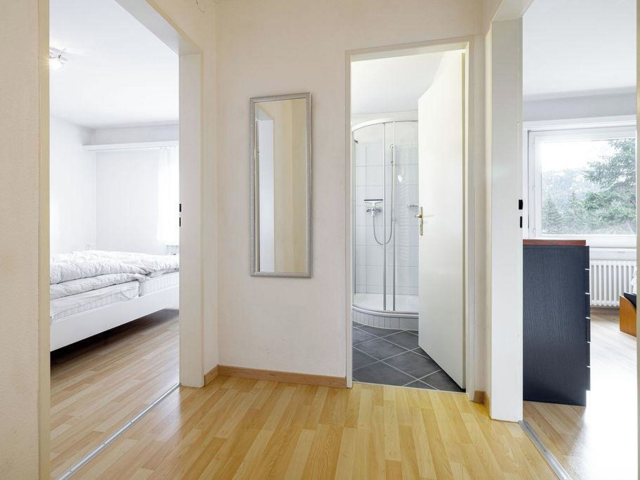 Ein Zimmer mit einem Bett, einer Dusche und Blick ins Freie.