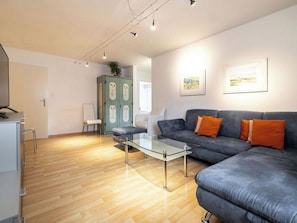 Ein modernes Wohnzimmer mit einer Couch, einem Glastisch und einem Schrank.