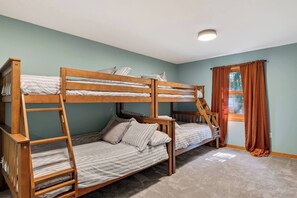 A bunk bed room with a window and curtains.
