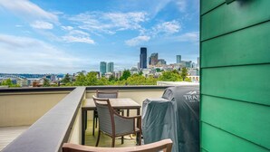 A rooftop terrace with a table and chairs, a grill, and a city skyline view. - Rooftop Brews & Mtn Views: Central Seattle Gem (Seattle)
