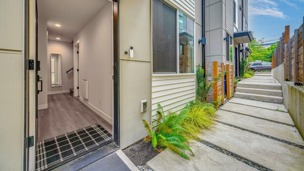 A residential entryway with a door, a staircase leading to a second floor, and a concrete pathway with a small garden. - Rooftop Brews & Mtn Views: Central Seattle Gem (Seattle)