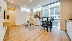 A modern apartment with a dining area, a sofa, and a kitchen. - Rooftop Brews & Mtn Views: Central Seattle Gem (Seattle)