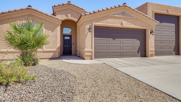 A house with a garage, a driveway, and a small palm tree. - Family Haven 4 Mi to Lake Havasu & London Bridge! (Lake Havasu City)