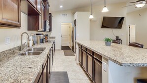A kitchen with granite countertops, stainless steel appliances, wooden cabinets, and pendant lighting. - Family Haven 4 Mi to Lake Havasu & London Bridge! (Lake Havasu City)