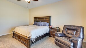 A bedroom with a bed, a ceiling fan, a nightstand, and a leather chair. - Family Haven 4 Mi to Lake Havasu & London Bridge! (Lake Havasu City)