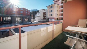 Un balcón con vista a un edificio que dice 'PARADISES' y una montaña al fondo.