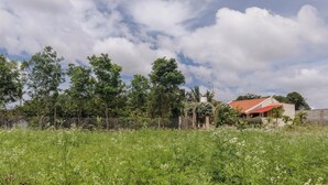 A rural landscape with a house, trees, and a field. - Myraa Farms by Stayjade2 Acrepvt Pooljacuzziac (Denkanikota)