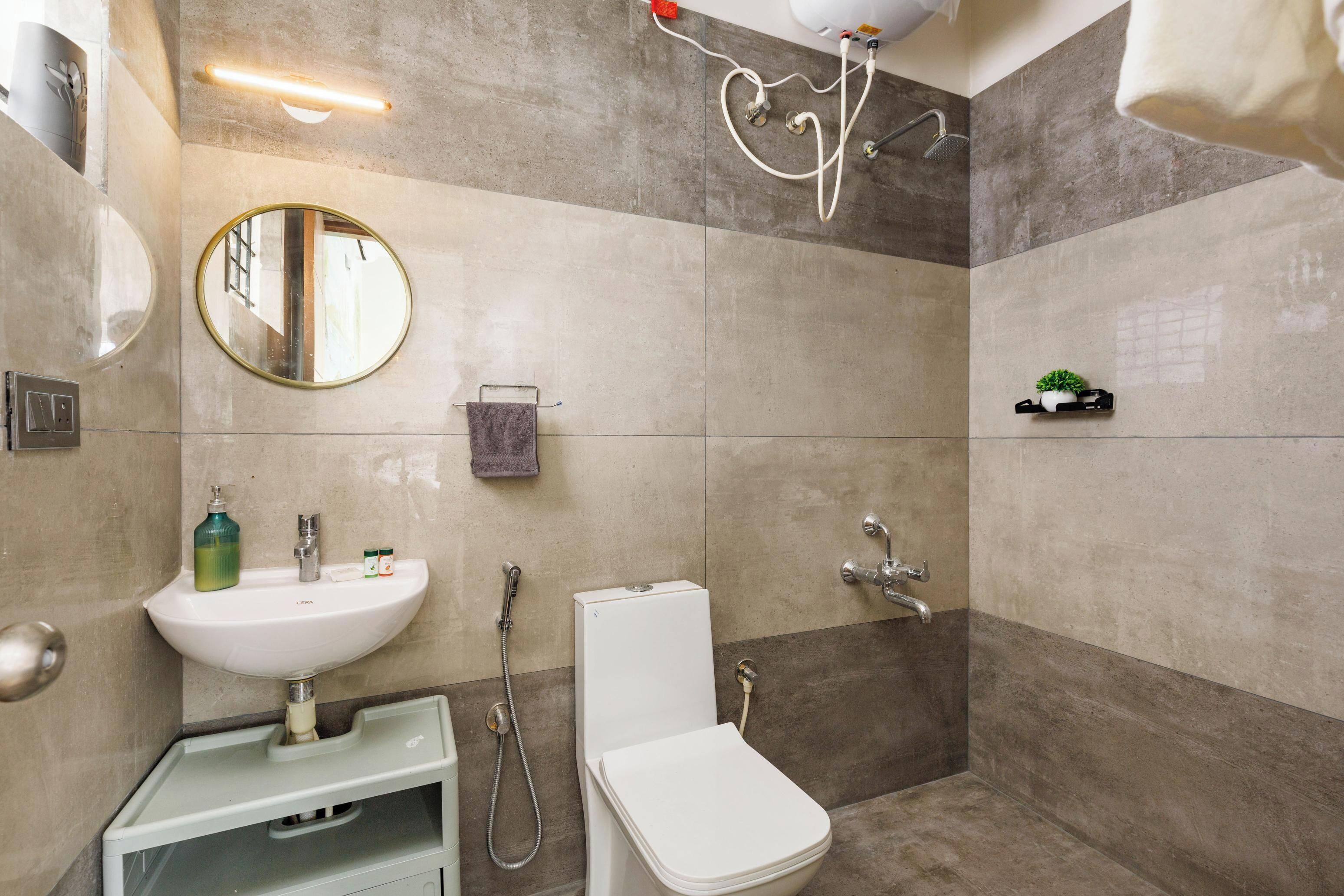 A bathroom with a sink, toilet, shower, and a mirror.