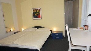 A hotel room with a bed, bedside tables, a desk, and a chair. - Paradies 505 Appartement/Fewo,  , 2-Bettwohnung 2-Bettwohnung by Interhome (Arosa)