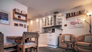 A compact living space with a kitchenette, a dining area, and a seating area with a sofa and chairs. - Paradies 607 Appartement/Fewo,  , 2-Bettwohnung 2-Bettwohnung by Interhome (Arosa)