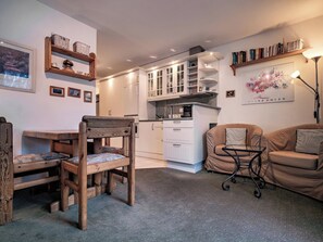 A compact living space with a kitchenette, a dining area, and a seating area with a sofa and chairs. - Paradies 607 Appartement/Fewo,  , 2-Bettwohnung 2-Bettwohnung by Interhome (Arosa)