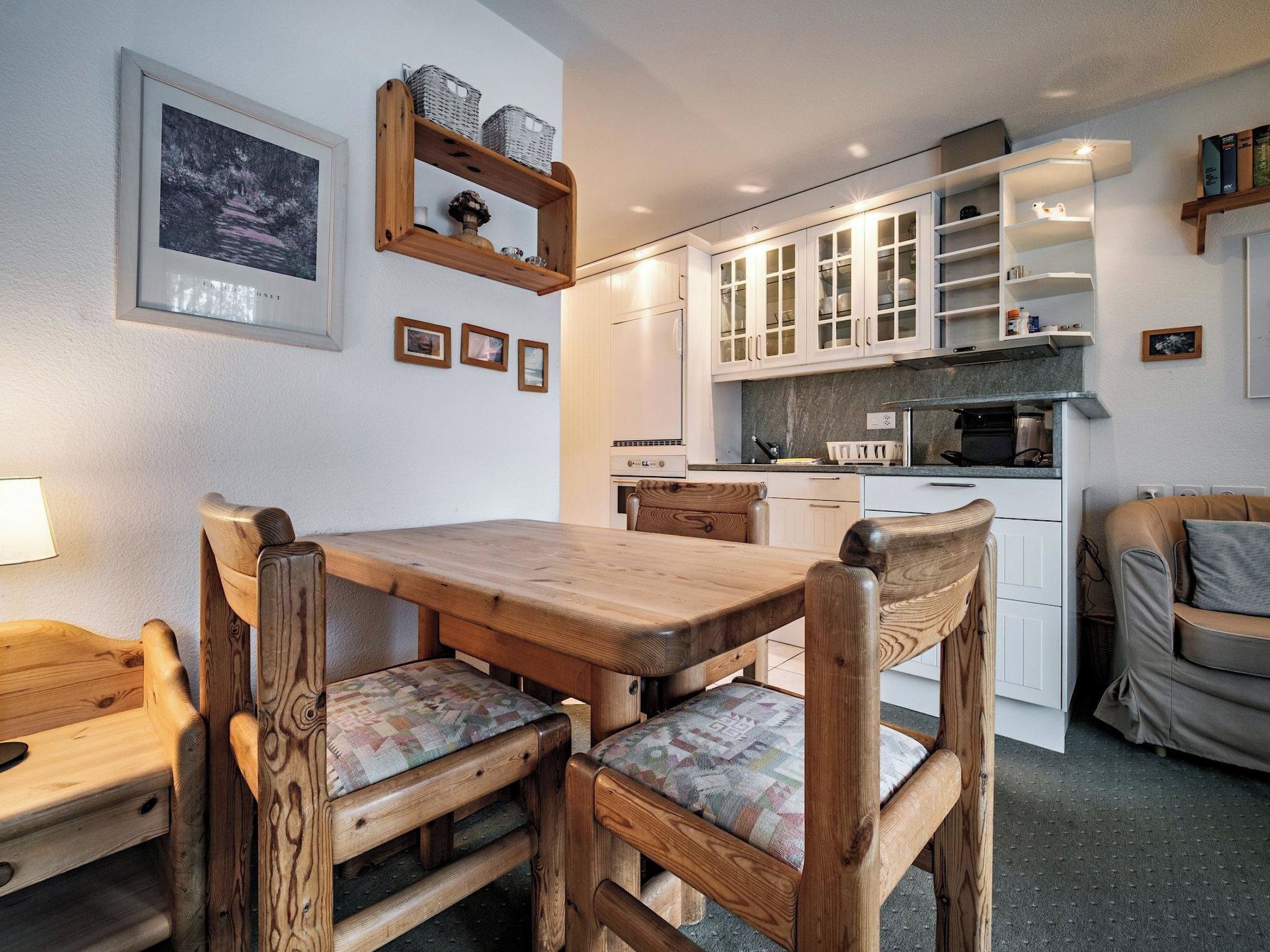 Een gezellige keuken met houten meubels, een eettafel en kastjes.