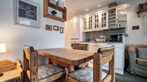 A cozy kitchen with wooden furniture, a dining table, and cabinets. - Paradies 607 Appartement/Fewo,  , 2-Bettwohnung 2-Bettwohnung by Interhome (Arosa)