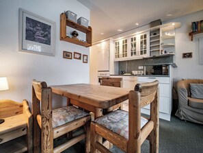 A cozy kitchen with wooden furniture, a dining table, and cabinets. - Paradies 607 Appartement/Fewo,  , 2-Bettwohnung 2-Bettwohnung by Interhome (Arosa)