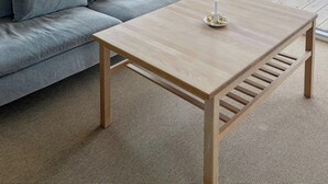 En moderne stue med en sofa, et sofabord og et stort vindue.