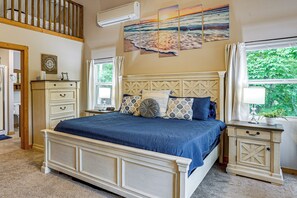 A bedroom with a large bed, a nightstand, a dresser, and a window with curtains. - Osage Beach Cabin With Private Dock and Lily Pad (Osage Beach)