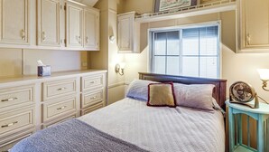 A bedroom with a bed, dresser, window, and wall-mounted fan. - Peaceful, Private Slice of Deep South Texas (San Benito)