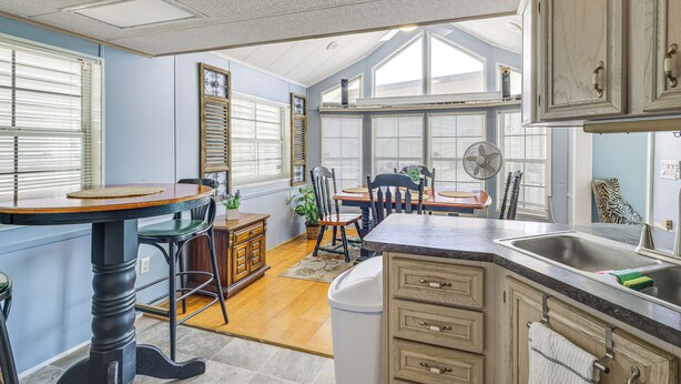 A kitchen with a dining area, wooden cabinets, a sink, and a fan. - Peaceful, Private Slice of Deep South Texas (San Benito)